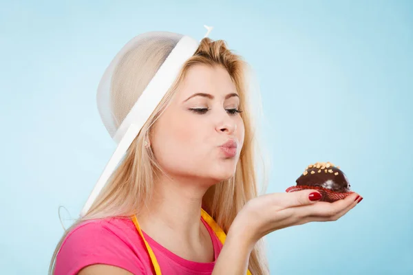 Mujer sosteniendo cupcake usando colador en la cabeza — Foto de Stock