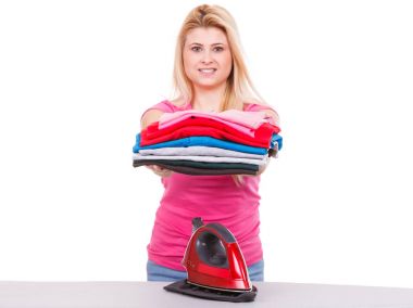 Katlanmış elbise yığını tutan kadın