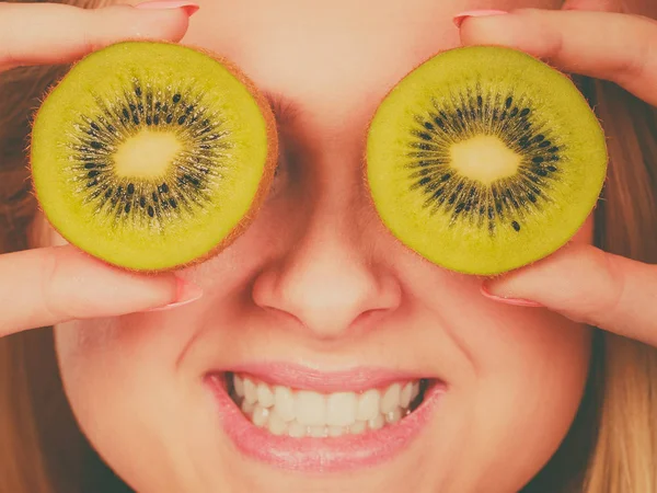 Vrouw met groene kiwi fruit zoals brillen — Stockfoto