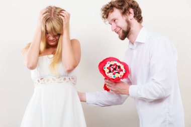 Adam şeker demet çiçek üzgün kadın için veriyor..