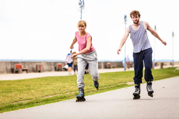 활동적인 젊은 이들이 친구 rollerskating 야외. — 스톡 사진