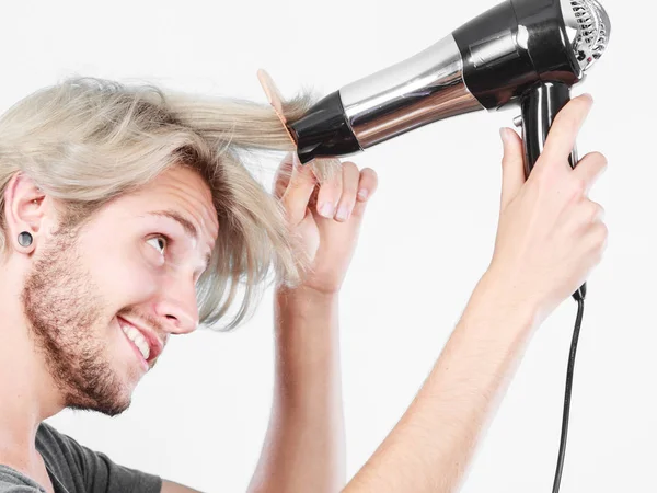 Ung man torka håret med hårtork — Stockfoto