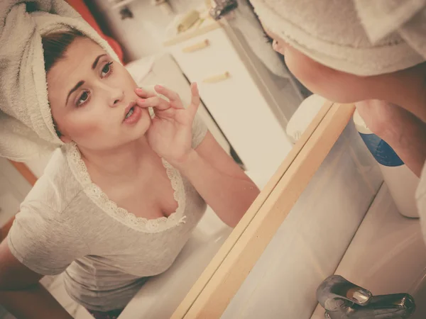 Vrouw kijkt naar haar reflectie in spiegel — Stockfoto