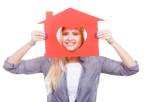 Sonriente chica sosteniendo casa de papel rojo con forma de corazón — Foto de Stock