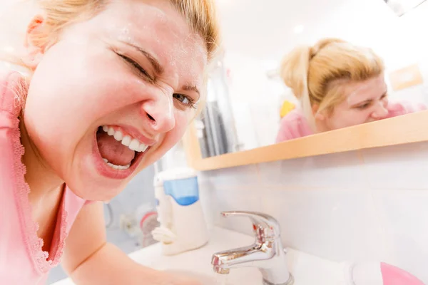 Mujer feliz lavándose la cara bajo el lavabo — Foto de Stock