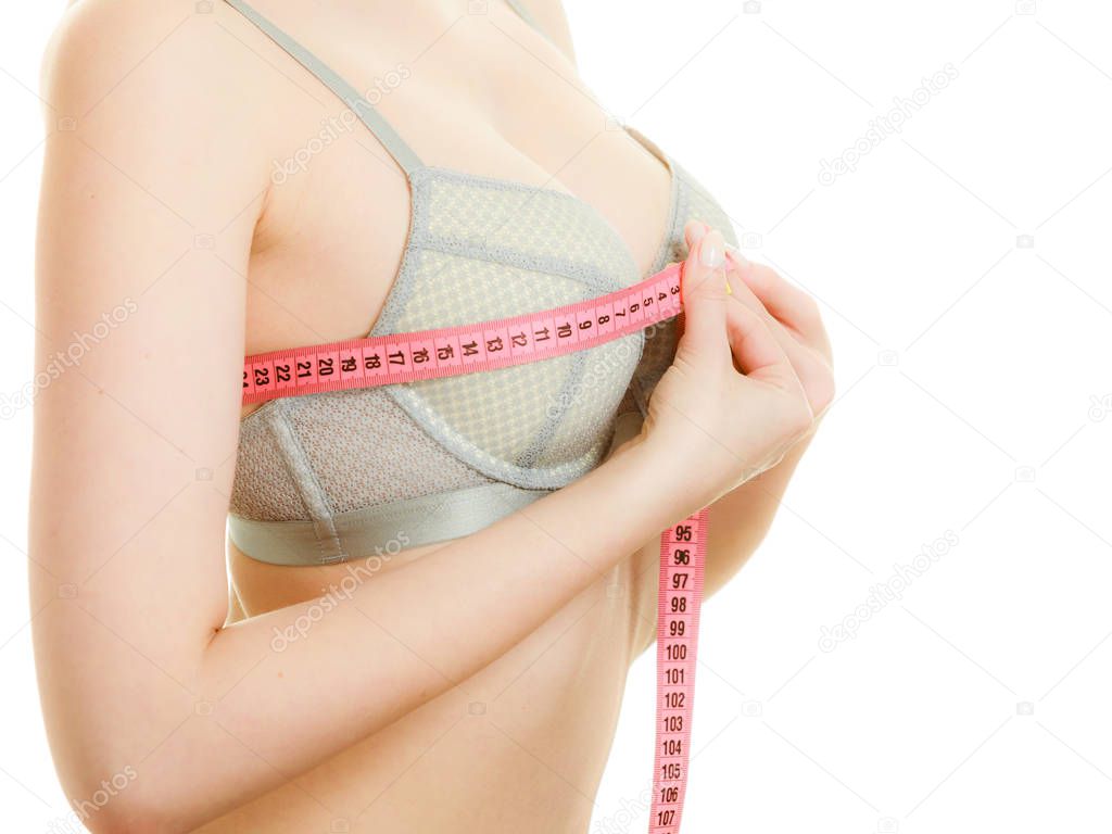 Woman in bra lingerie measuring her chest breasts.