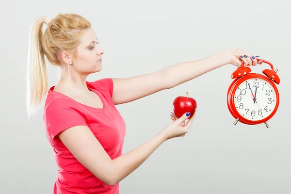 Mujer feliz sosteniendo reloj, manzana y cinta métrica —  Fotos de Stock