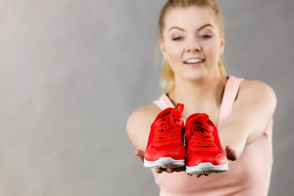 Femme heureuse présentant des chaussures de baskets de sport — Photo