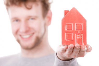 Genç adam evin üstünde palmiye holding.