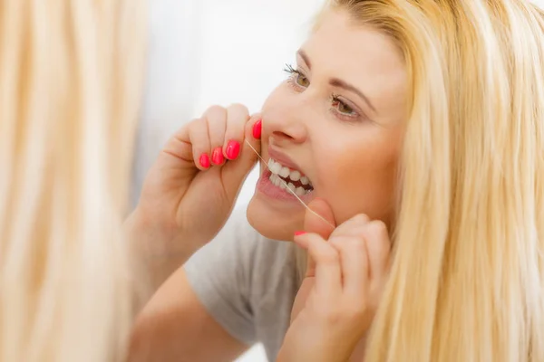 Femme se nettoie les dents à l'aide de fil dentaire — Photo