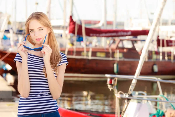 Kvinna i marina mot båtar i hamn — Stockfoto