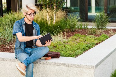 Hipster adam kenarında oturan tablet ile