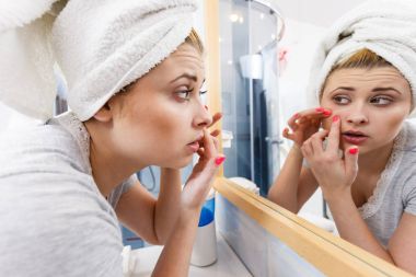 Akne başa ayna arayan kadın