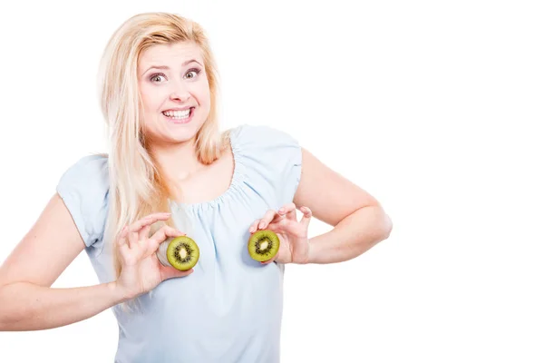 Vrouw bedrijf groene kiwi op borst — Stockfoto