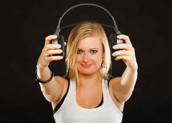 Blonde woman holding big headphones in studio — Stock Photo, Image