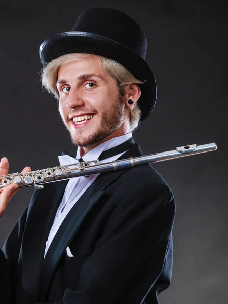 Элегантно одетый музыкант держит флейту — стоковое фото