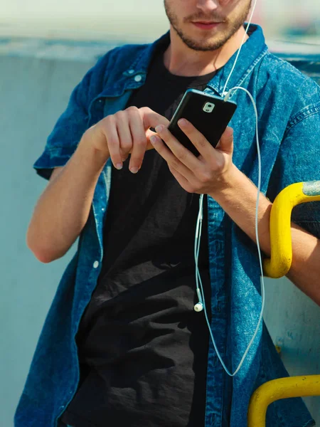 Blonde man outside using his smartphone