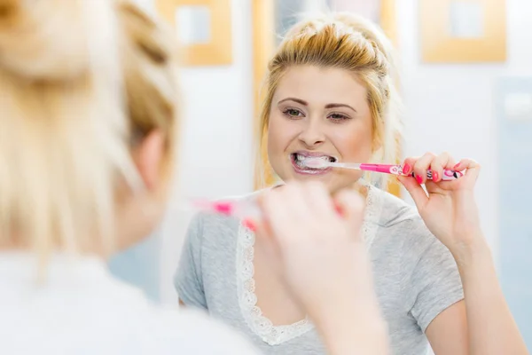 Woman brushing cleaning teeth in bathroom — Stock Photo, Image