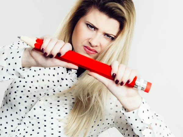 Angry woman holds big pencil in hand — Stock Photo, Image