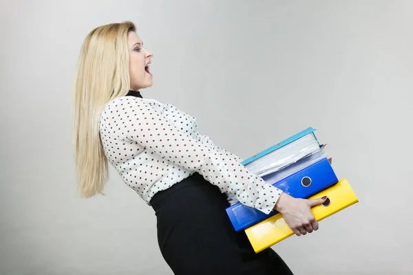 Жінка тримає важкі барвисті зв'язувачі з документами — стокове фото
