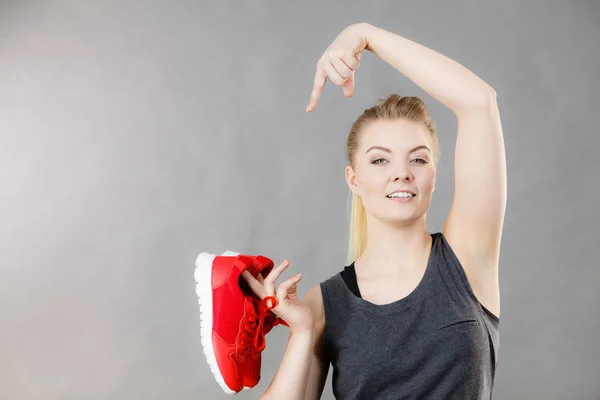 Femme heureuse présentant des chaussures de baskets de sport — Photo