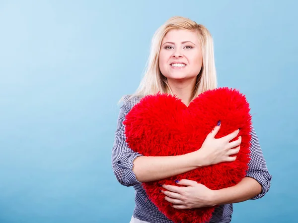 Mujer feliz sosteniendo almohada roja en forma de corazón — Foto de Stock