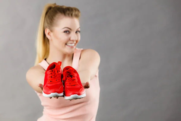 Glückliche Frau präsentiert Sportbekleidung Turnschuhe — Stockfoto