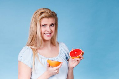 Kırmızı greyfurt tutan mutlu gülümseyen kadın