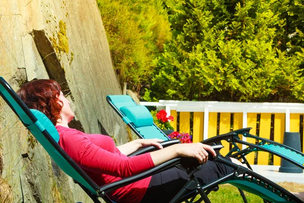 Mulher adulta relaxante na espreguiçadeira no jardim — Fotografia de Stock