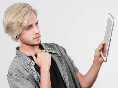 Tablet düşünme kullanarak trendy genç adam