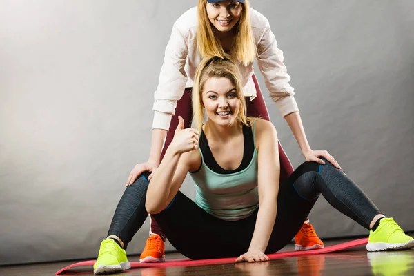 Donna in abbigliamento sportivo gambe stretching con allenatore — Foto Stock