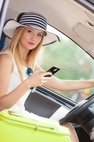 Arabasını kullanırken telefonu kullanan bir kadın.