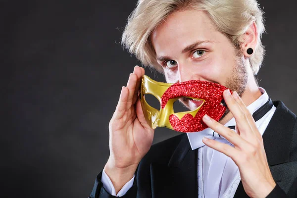 Ung man i carnival mask på mörk — Stockfoto