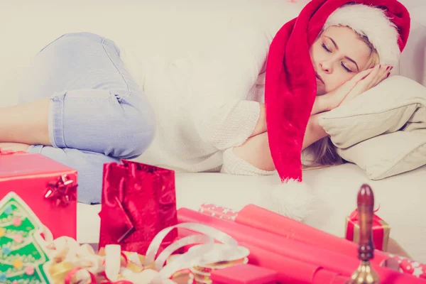 Femme dans le chapeau de Père Noël dormant sur le canapé — Photo