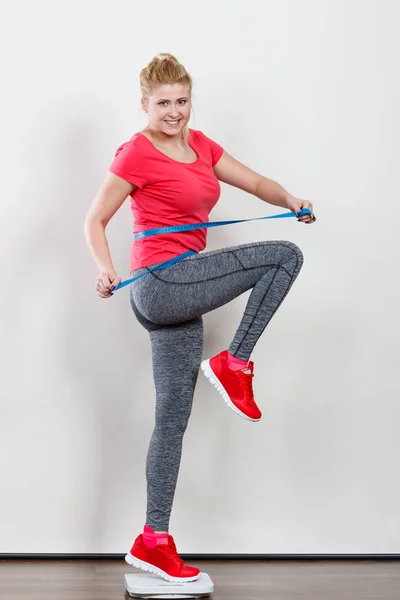 Vrouw het dragen van sportkleding staande op gewicht machine — Stockfoto