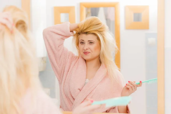 Femme portant une robe de chambre se brossant les cheveux — Photo