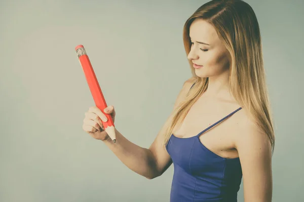 Mujer positiva sostiene lápiz grande en la mano — Foto de Stock