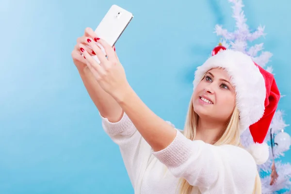 Woman in santa hat taking selfie — Stock Photo, Image