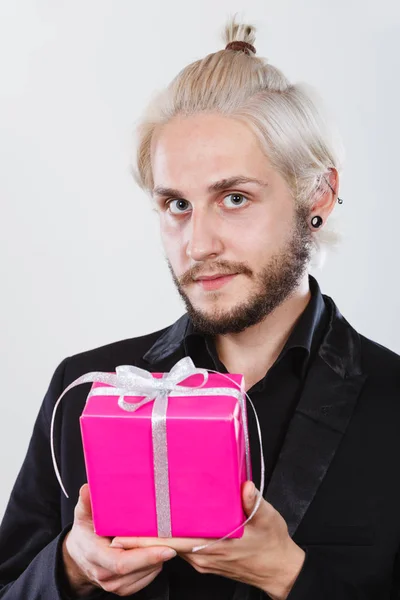 Ember a kezében tartja a jelenlegi rózsaszín ajándék doboz — Stock Fotó