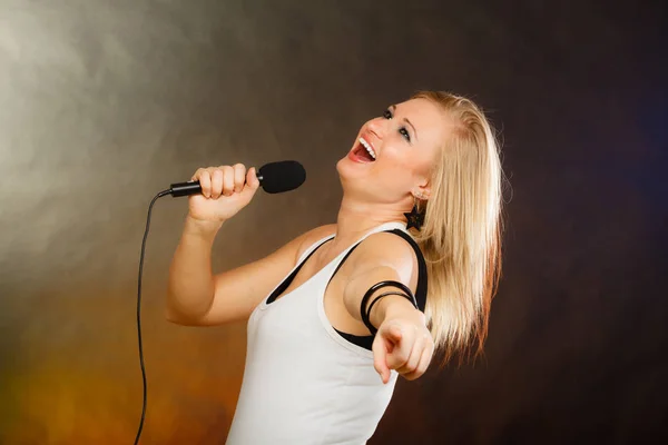 Blonde woman singing to microphone — Stock Photo, Image