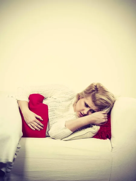 Femme se sentant crampes d'estomac couché sur cofa — Photo