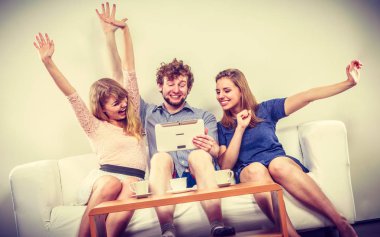 Evde tablet ile başarılı mutlu arkadaşlar.