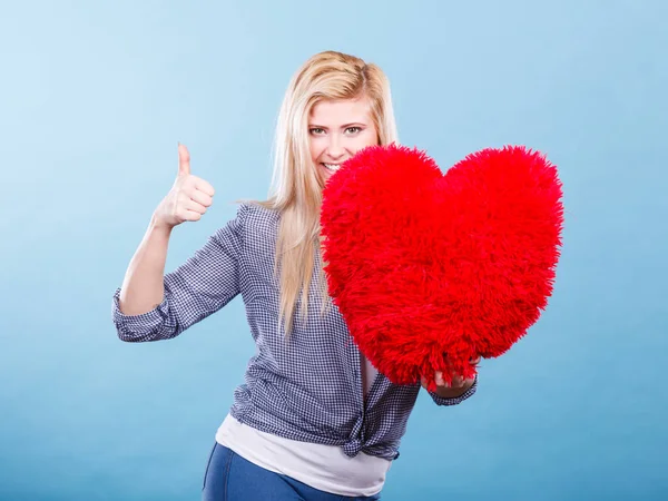 Щаслива жінка тримає червону подушку у формі серця — стокове фото