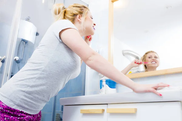Женщина чистит зубы в ванной комнате — стоковое фото