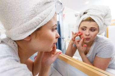 Akne başa ayna arayan kadın