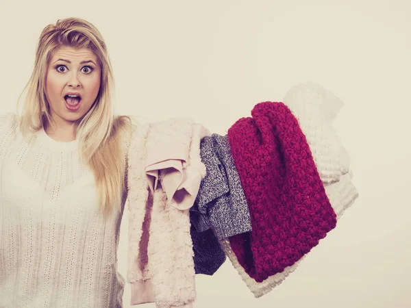 Mulher chocada segurando pilha de roupas de inverno — Fotografia de Stock