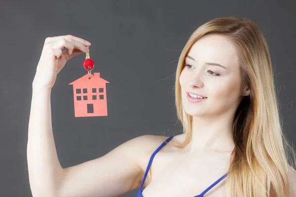 Mujer sosteniendo la llave con símbolo de la casa — Foto de Stock