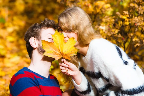 Paar met maple leaf zoenen in herfst park — Stockfoto