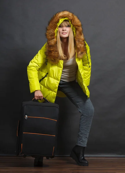 Junge Frau in warmer Jacke mit Koffer. — Stockfoto