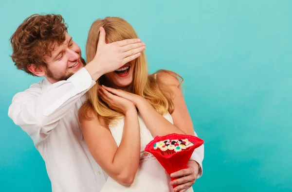 Homem dando mulher doce monte cobrindo seus olhos . — Fotografia de Stock